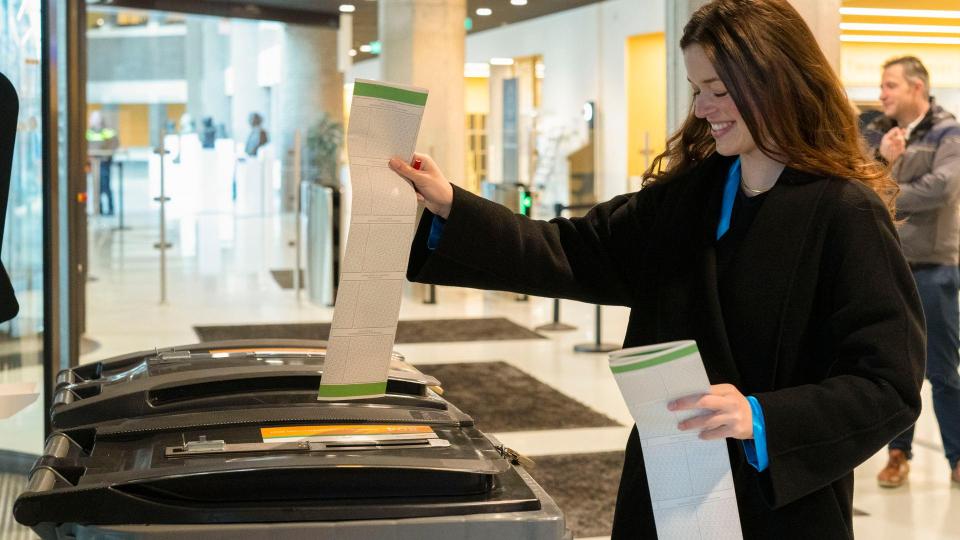 Een vrouw doet haar stembiljet in de stembus