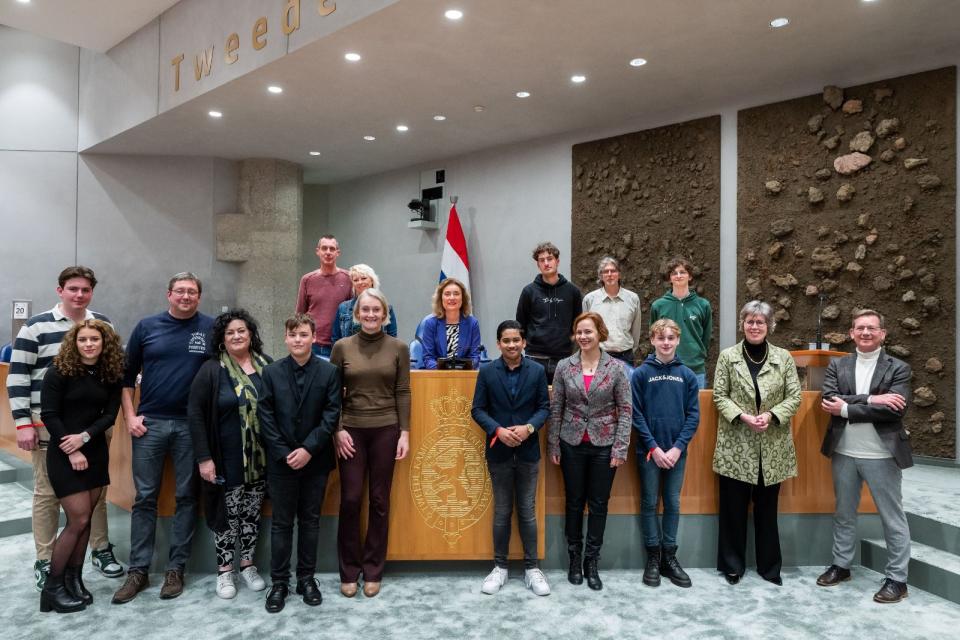 Kamerleden staan met briefschrijvers op een rij in de plenaire zaal