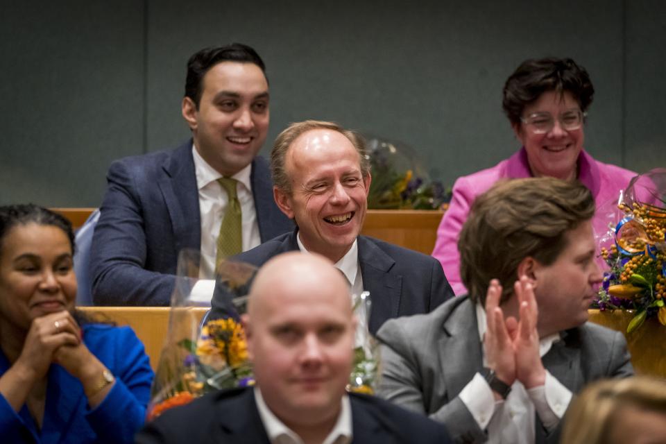 Kees van der Staaij zit lachend in de plenaire zaal met 5 andere Kamerleden om hem heen.