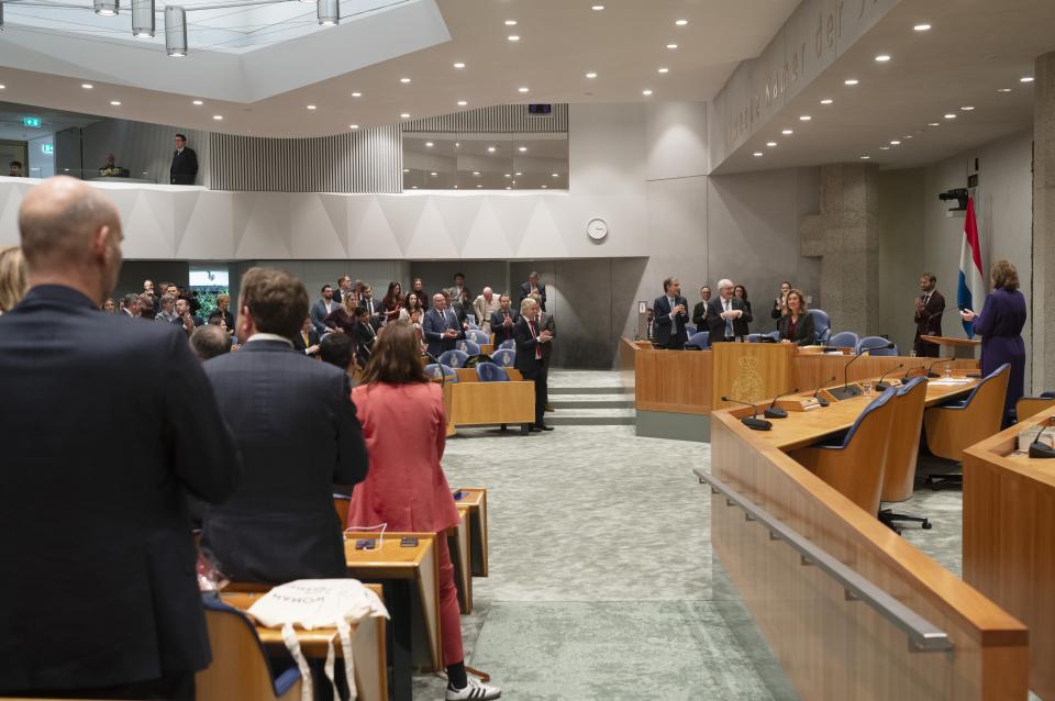 Kamerleden staan in de plenaire zaal en klappen bij het afscheid van Kamervoorzitter Vera Bergkamp.