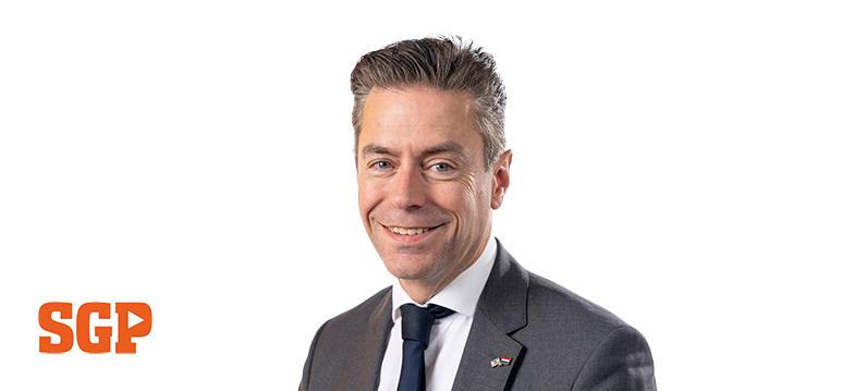 Portretfoto Chris Stoffer met partijlogo SGP