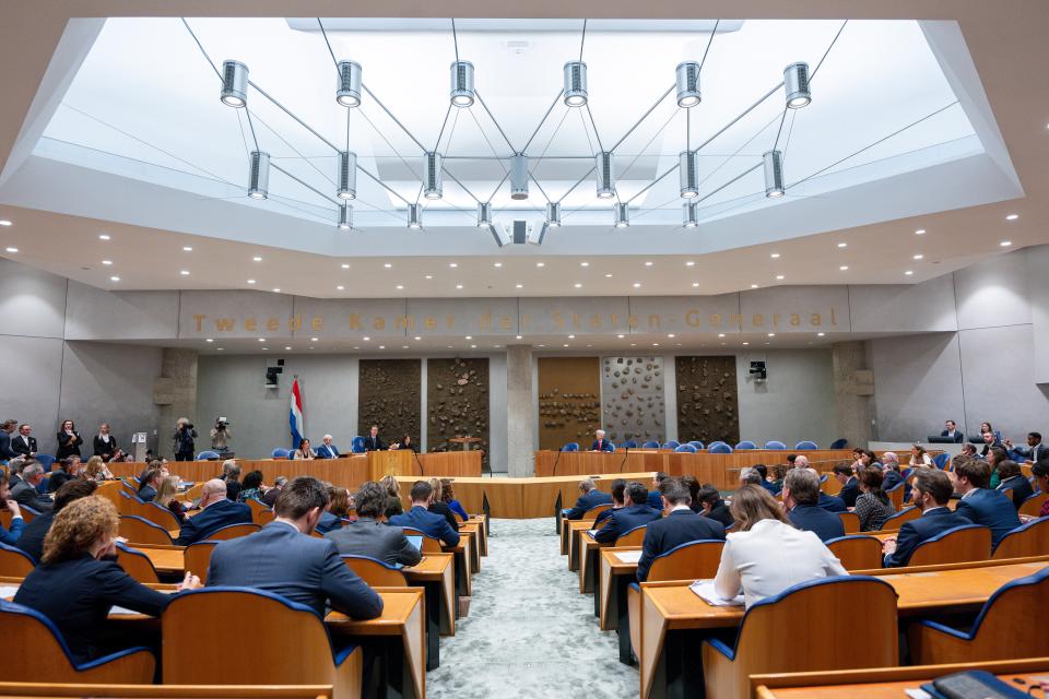 Kamerleden zitten op hun plek in de plenaire zaal aan het begin van het debat op 14/2/24