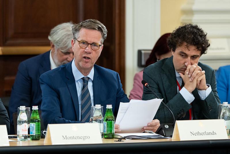 Op de foto zit Kamervoorzitter, de heer Bosma aan een tafel en leest een speech voor. Naast hem zit delegatieleider de heer Klaver.