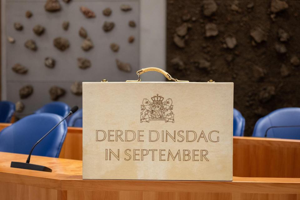 Beeld van lichtgekleurd rechtopstaand koffertje met opdruk 'Derde dinsdag van september'