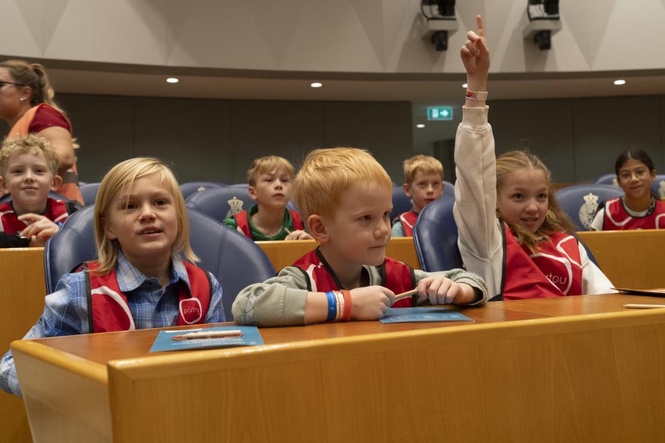 Kinderen van 6 tot 9 jaar zitten in de zetels in de plenaire zaal