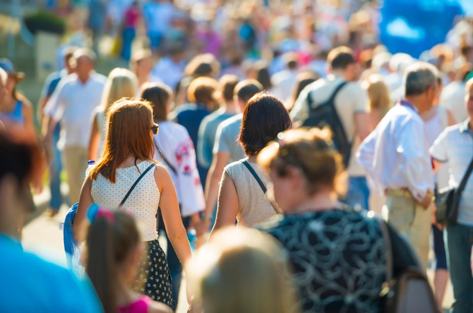 een grote groep mensen op straat van achter gefotografeerd