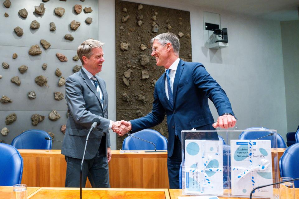 Kamervoorzitter Martin Bosma schudt de hand van Pieter Duisenberg, president van de Algemene Rekenkamer, in de plenaire zaal. Voor hen staat het koffertje met de stukken die de Rekenkamer aanbiedt.