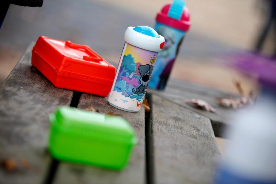 Een aantal lunchtrommels en drinkbekers van kinderen op een tafel.