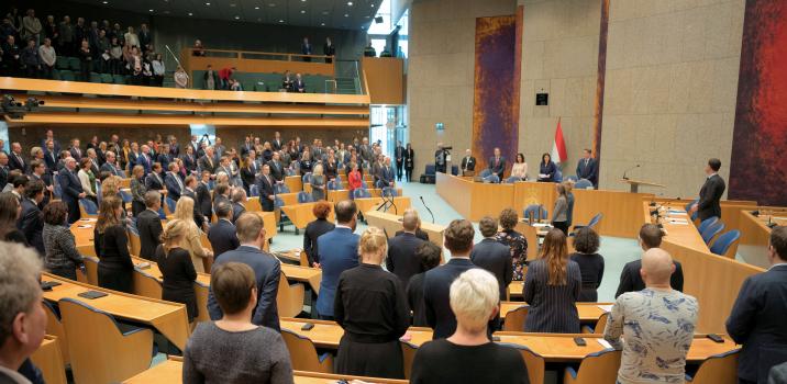 Kamerleden staand in plenaire zaal