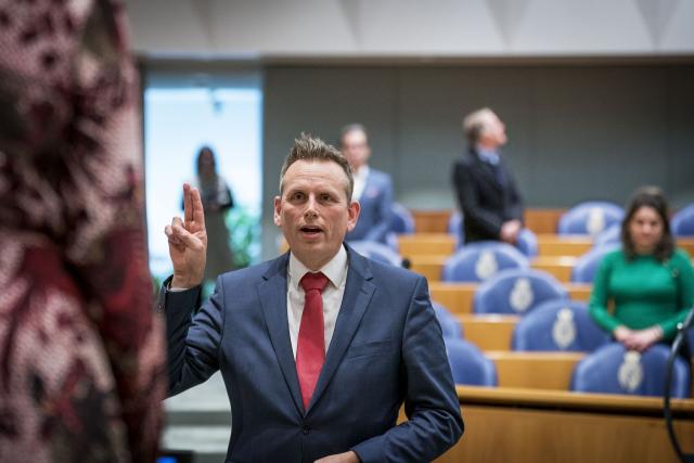 Evert Jan Slootweg staat tegenover de Kamervoorzitter, steekt zijn wijsvinger en middelvinger van zijn rechterhand in de lucht en spreekt de eed uit