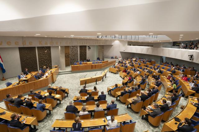 Demissionair minister-president Mark Rutte legt een verklaring af in de plenaire zaal ten overstaande van Kamerleden die op de vergaderstoelen zitten.