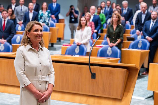 Het Kamerlid staat midden in de plenaire zaal, vóór de Kamervoorzitter, om te worden beëdigd. 