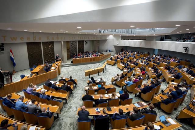 Overzicht van de plenaire zaal met Kamerleden in de zetels en kabinetsleden in vak K.