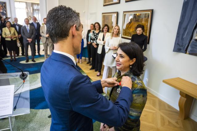 Voorzitter Khadija Arib krijgt de versierselen behorend bij de Franse onderscheiding opgespeld.