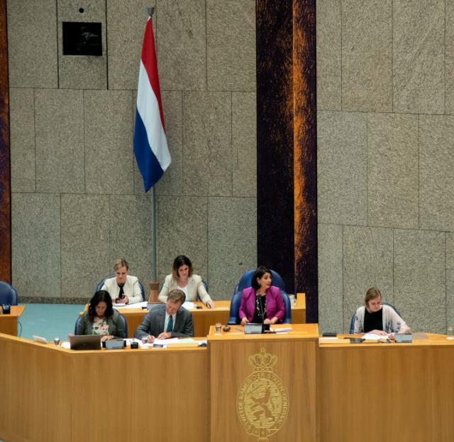 De nieuwe vlag achter de stoel van de Kamervoorzitter